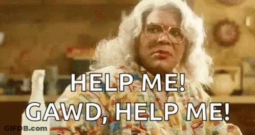 Woman In Wig And Glasses Sitting In Kitchen GIF