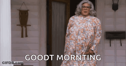 Woman In Wig And Glasses Sitting In Kitchen GIF