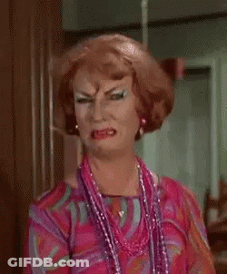 Woman In Wig And Necklace Making A Face GIF
