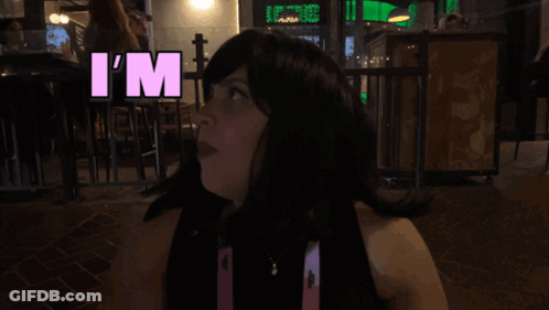 Woman In Wig Says Overstimulated In Pink Letters GIF