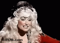 Woman In Wig Singing Into Microphone And Smiling GIF