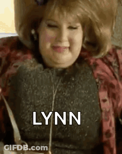 Woman In Wig Smiling Holding Purse GIF