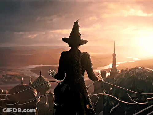 Woman In Witch Hat On Balcony Overlooking City GIF