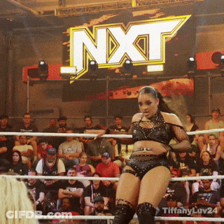 Woman In Wrestling Ring In Front Of NXT Sign GIF