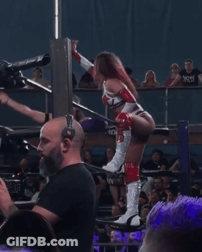 Woman In Wrestling Ring With Bearded Man Behind Her GIF