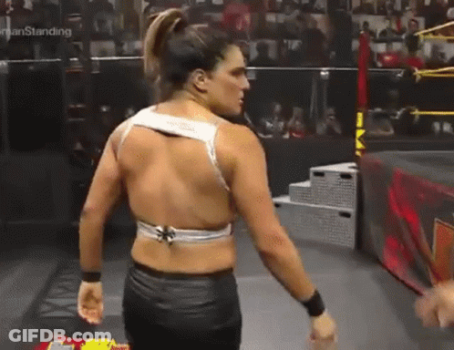 Woman In Wrestling Ring With Man Behind Her GIF