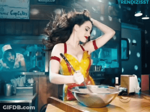 Woman In Yellow And Red Dress Stirring Bowl GIF