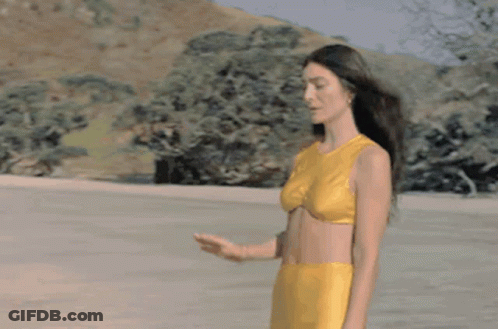 Woman In Yellow Bikini On Sandy Beach GIF