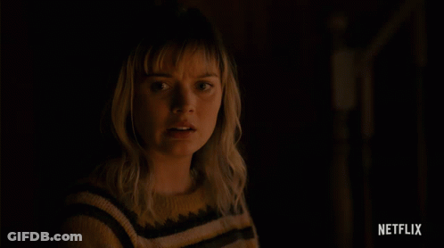 Woman In Yellow Black Striped Sweater With Netflix Logo Above GIF