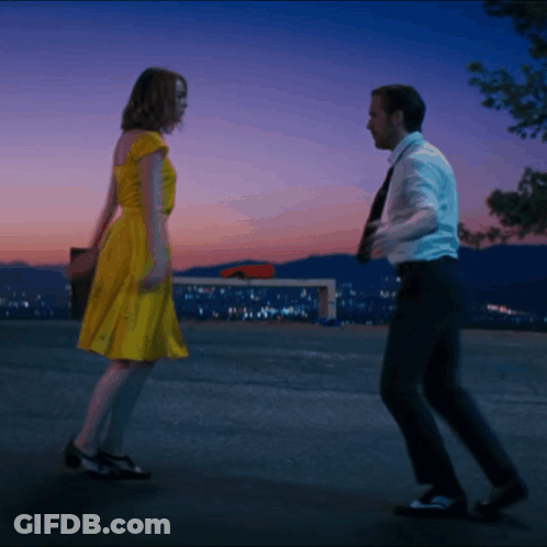 Woman In Yellow Dress Dancing With Man In Suit GIF
