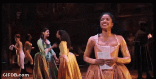 Woman In Yellow Dress Holding Paper Smiling GIF