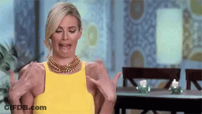Woman In Yellow Dress Making Funny Face Holding Arms Out GIF