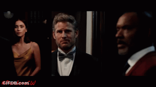 Woman In Yellow Dress Next To Man In Tuxedo And Bow Tie GIF
