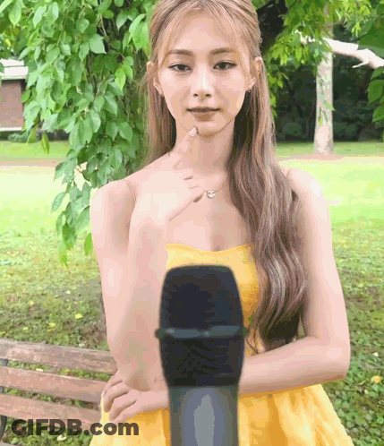 Woman In Yellow Dress Pointing At Microphone GIF