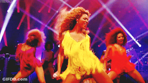 Woman In Yellow Dress Singing Into Microphone Dancing On Stage GIF