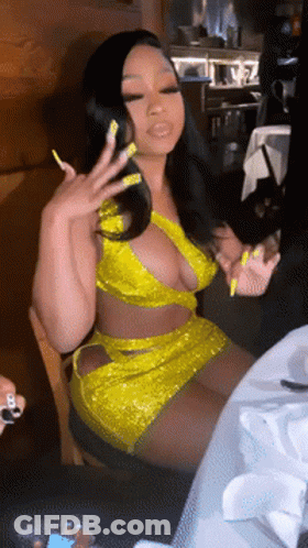 Woman In Yellow Dress Sitting At Table GIF
