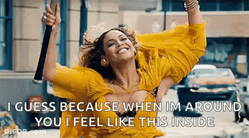 Woman In Yellow Dress Smiling Holding Microphone GIF