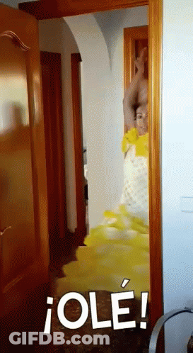 Woman In Yellow Dress Standing In Doorway GIF
