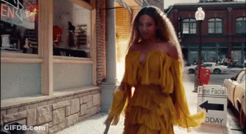 Woman In Yellow Dress Walking Down City Street GIF