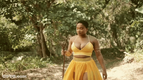 Woman In Yellow Dress With Cane In Forest GIF