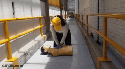 Woman In Yellow Hat Giving Heart Massage To Mannequin GIF