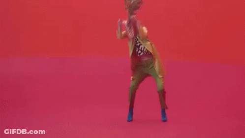Woman In Yellow Jacket And Green Pants Dancing GIF