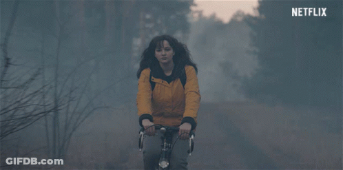 Woman In Yellow Jacket Riding Bike With Netflix Logo GIF