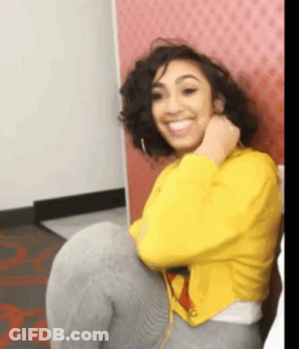 Woman In Yellow Jacket Sitting On Chair Smiling GIF