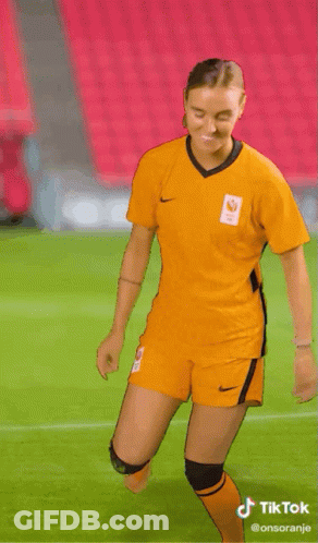 Woman In Yellow Nike Jersey Dancing On Soccer Field GIF