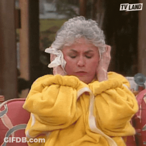 Woman In Yellow Robe Covering Ears With Towel GIF