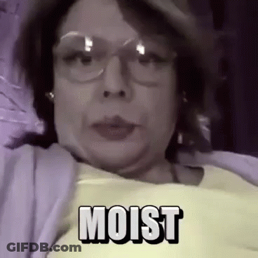 Woman In Yellow Shirt And Glasses Lying In Bed Moist GIF