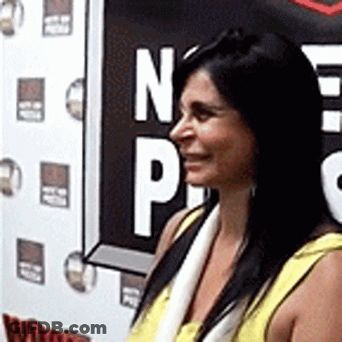 Woman In Yellow Shirt In Front Of NP Sign GIF