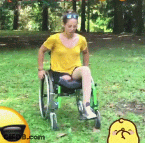 Woman In Yellow Shirt In Wheelchair In Park GIF