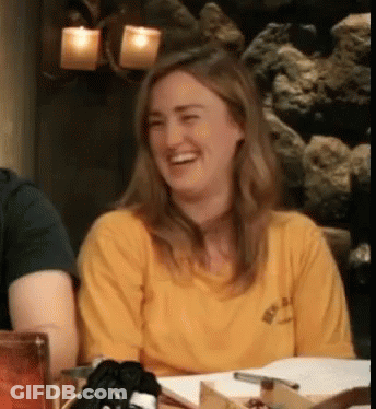 Woman In Yellow Shirt Laughing At Table With Others GIF