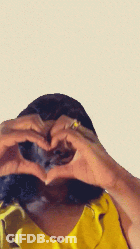 Woman In Yellow Shirt Making Heart GIF