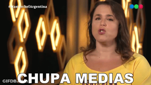 Woman In Yellow Shirt Says Chupa Medias In Front Of Neon Sign GIF