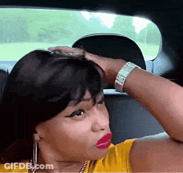 Woman In Yellow Shirt Sitting In Car With Hand On Head GIF