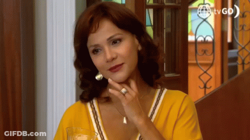Woman In Yellow Shirt Sitting In Front Of TV GIF