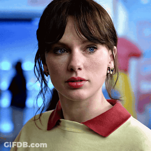Woman In Yellow Shirt With Red Collar And Earrings GIF