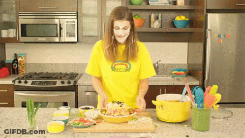 Woman In Yellow Smiley Shirt Cooking GIF