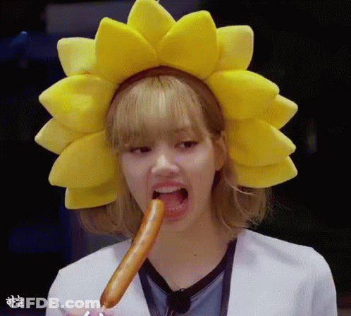 Woman In Yellow Sunflower Headband Eating Sausage GIF