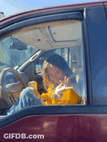 Woman In Yellow Sweater Sitting In Red Car GIF