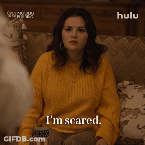 Woman In Yellow Sweater Sitting On Couch GIF