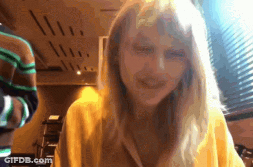 Woman In Yellow Sweater Smiling At Camera GIF