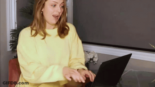 Woman In Yellow Sweater Using Laptop GIF