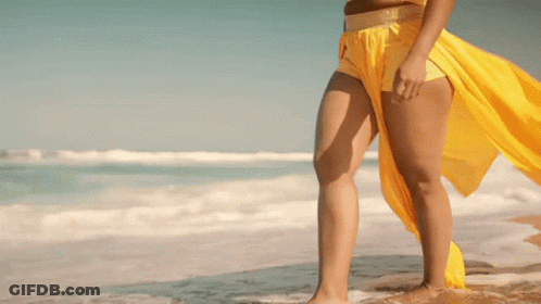 Woman In Yellow Top And Shorts On Beach GIF