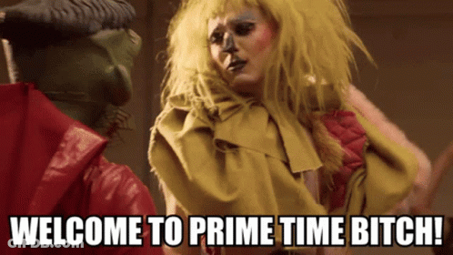 Woman In Yellow Wig Next To Man Saying Welcome To Prime Time Bitch GIF