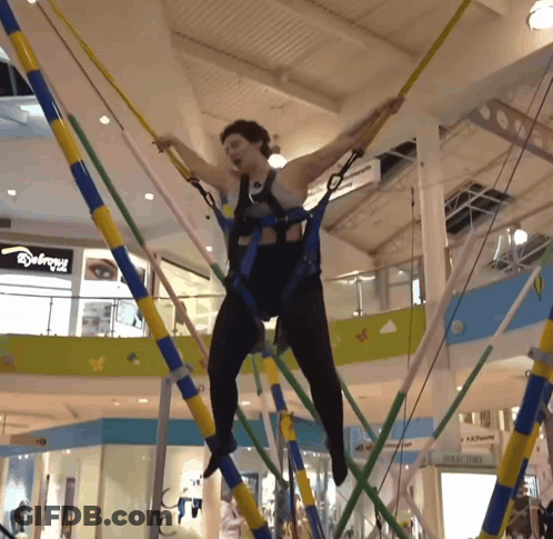 Woman Jumping On Trampoline In Mall With Abercrombie Sign GIF