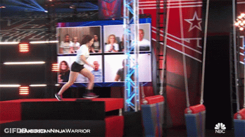 Woman Jumping Over Barrier In Front Of NBC Screen GIF