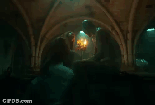 Woman Kissing Man In Front Of Candles GIF